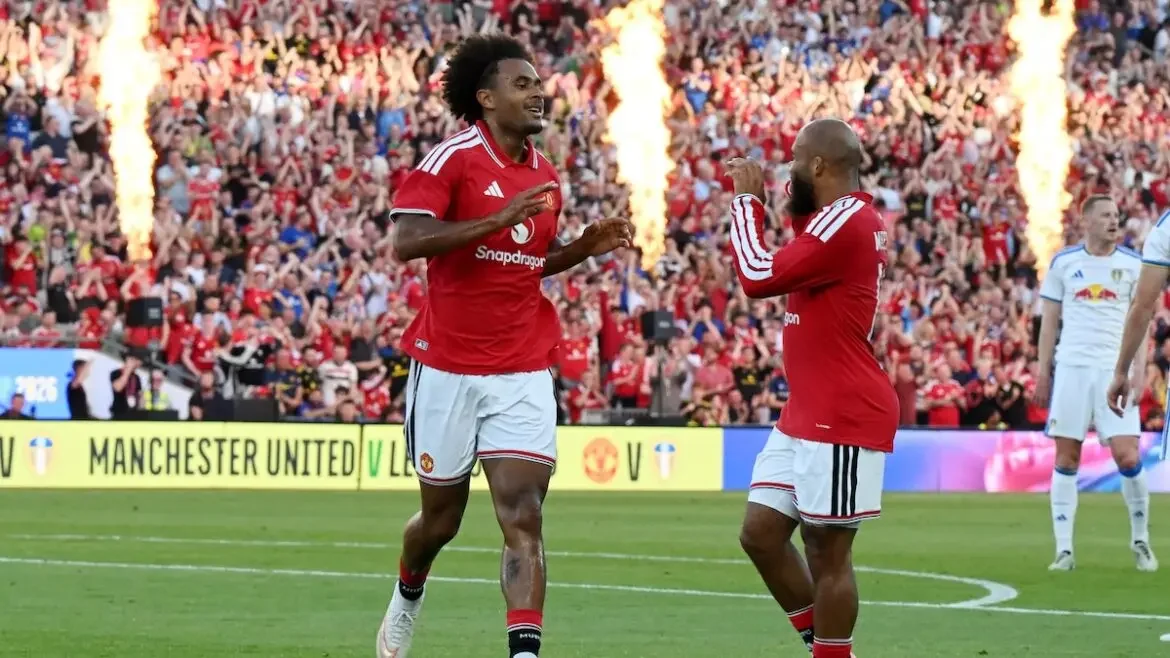 Joshua Zirkzee celebrating in a Manchester United home kit during a match at Old Trafford